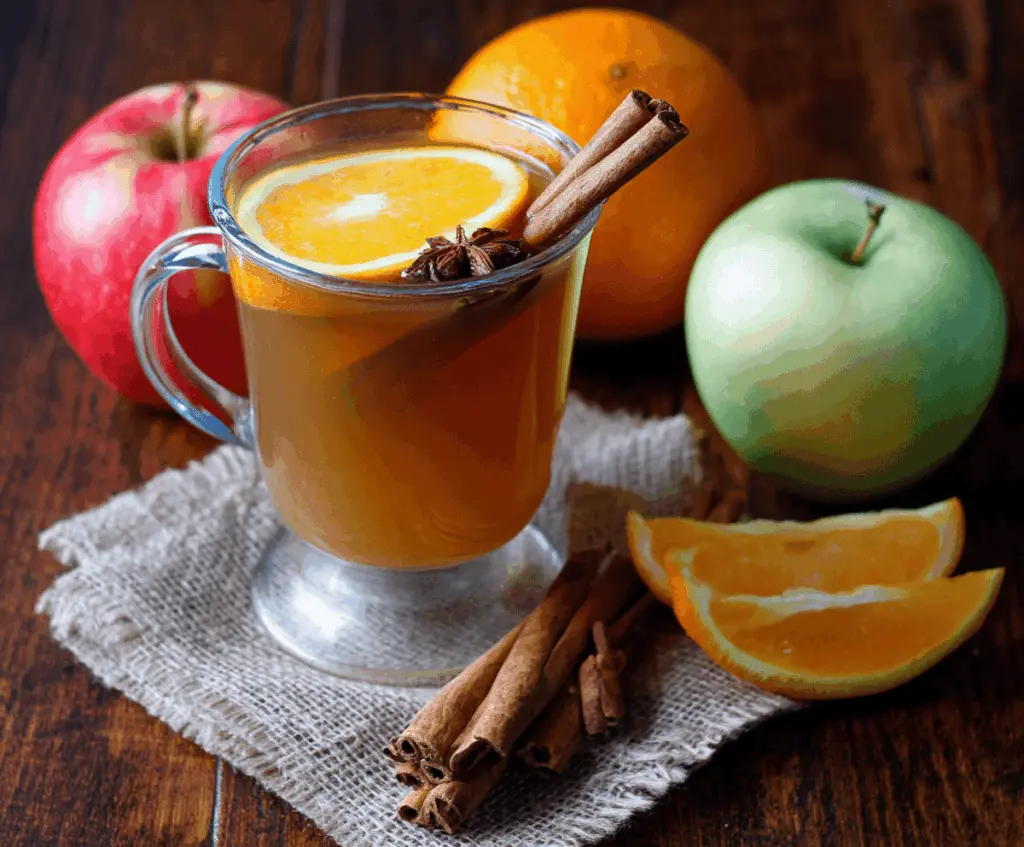Warm homemade hot mulled apple cider with cinnamon sticks, cloves, and orange slices in a festive mug, perfect for cozy winter evenings.