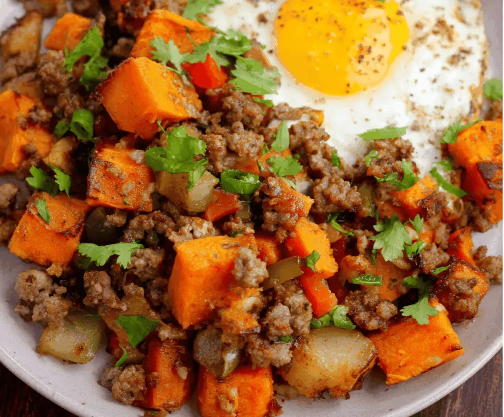 Delicious sheet-pan ground beef and sweet potato hash topped with fresh herbs, ready to serve