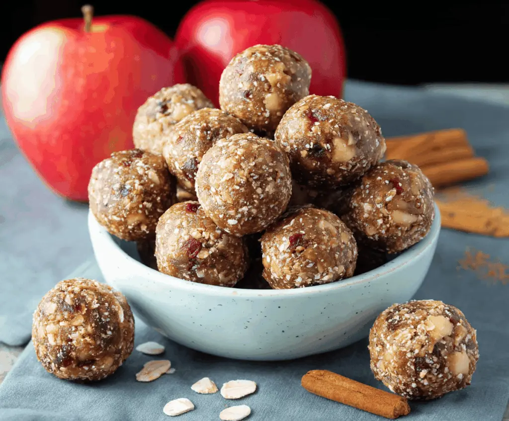 Delicious Apple Pie Energy Balls with cinnamon, oats, and chopped apples on a white plate, healthy snack option