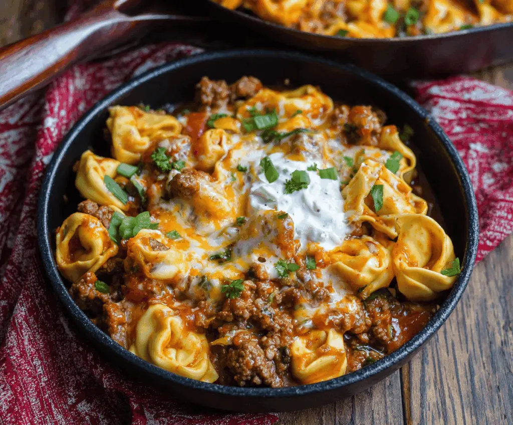 Delicious Beef Enchilada Tortellini served on a plate with melted cheese and fresh herbs, showcasing a flavorful fusion pasta dish
