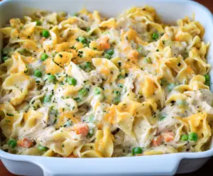 Creamy chicken noodle casserole in a baking dish with melted cheese and herbs