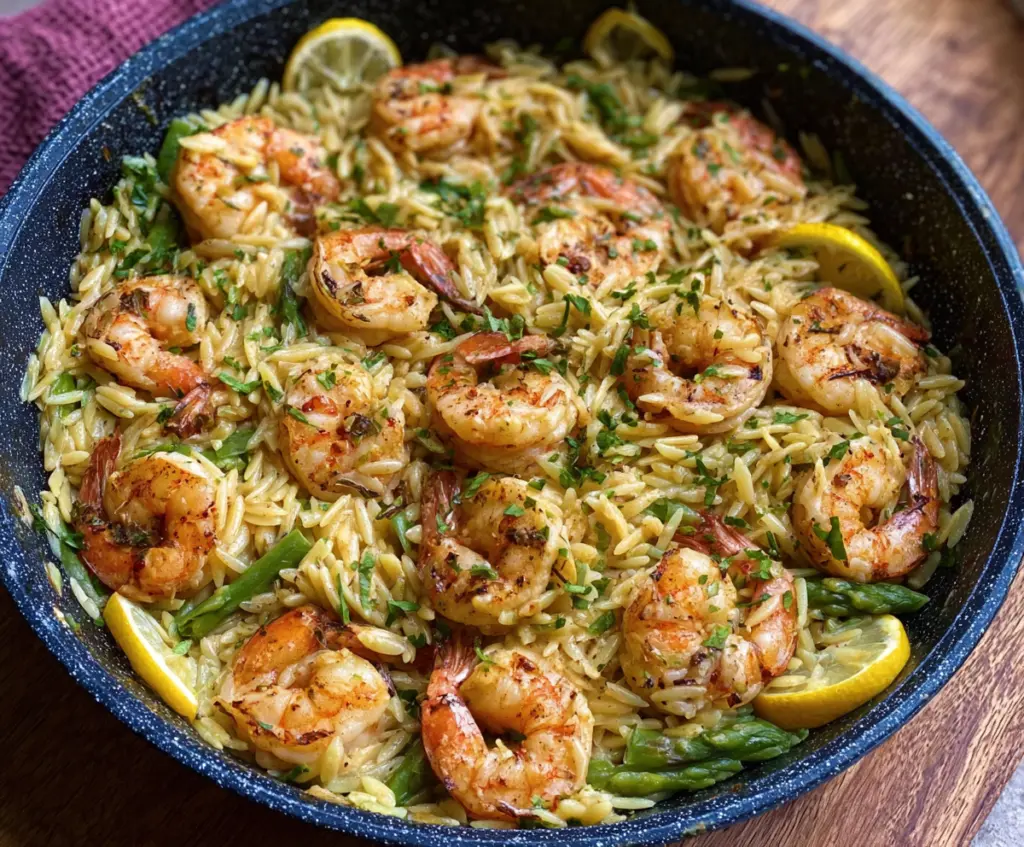 Delicious shrimp orzo pasta in a vibrant lemon garlic sauce served on a white plate.