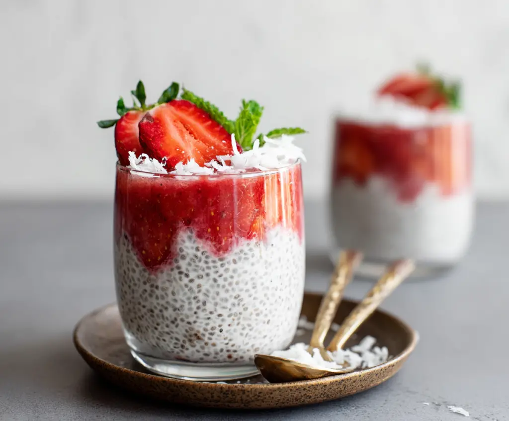 Delicious strawberry coconut chia pudding served in a glass bowl, garnished with fresh strawberries and shredded coconut.